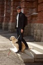 Blind man with disability walking down the stairs with a guide dog Royalty Free Stock Photo