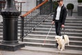 Blind man with disability walking down the stairs with a guide dog Royalty Free Stock Photo