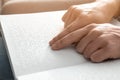 Blind man reading book written in Braille