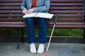 Blind man reading braille book, sitting on bench in summer park, resting Royalty Free Stock Photo