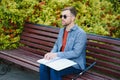 Blind man reading braille book, sitting on bench in summer park, resting Royalty Free Stock Photo