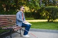 Blind man reading braille book, sitting on bench in summer park, resting Royalty Free Stock Photo