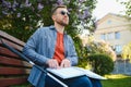 Blind man reading braille book, sitting on bench in summer park, resting Royalty Free Stock Photo