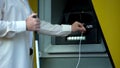 Blind man searching audio jack in talking atm, using headset to withdraw money