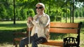 Blind man sitting on bench, listening for sounds in park, heightened senses