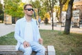 Blind man with a walking stick sitting on a bench at a park Royalty Free Stock Photo