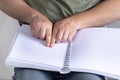 Blind man was reading a book written on Braille. Horizontal