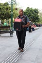 A blind man busk along the sidewalk