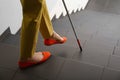 Blind person with long cane going down stairs, Royalty Free Stock Photo