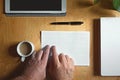 Blind person touching reading a braille text on a desk in a workplace.