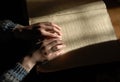 Blind reading text in braille. close-up of human hands reading b