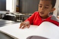 Blind schoolboy reading a braille book at desk in a classroom Royalty Free Stock Photo