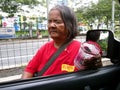 A blind street beggar asks for alms from a car driver