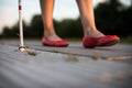 Blind woman walking on city streets, using her white cane