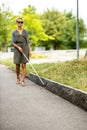 Blind woman walking on city streets, using her white cane