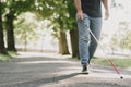 Blind young man in black sunglasses walking outdoors