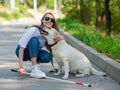 Blind young woman cuddling with guide dog on a walk outdoors. Royalty Free Stock Photo