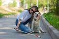 Blind young woman cuddling with guide dog on a walk outdoors. Royalty Free Stock Photo