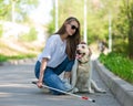 Blind young woman cuddling with guide dog on a walk outdoors. Royalty Free Stock Photo