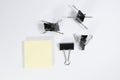 Blinder clips and memo pad on white background Royalty Free Stock Photo