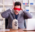 Blindfold businessman sitting at desk in office Royalty Free Stock Photo