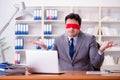 The blindfold businessman sitting at desk in office