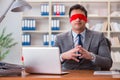 The blindfold businessman sitting at desk in office Royalty Free Stock Photo