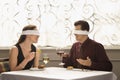 Blindfold couple dining