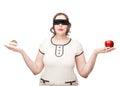 Blindfold plus size woman choosing between apple and cake Royalty Free Stock Photo