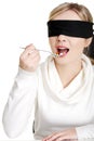 Blindfold woman holding spoon with pile of pills Royalty Free Stock Photo