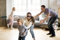 Blindfolded mother catching son playing hide and seek with famil