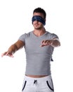 Blindfolded young man feeling his way in the dark