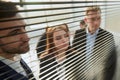 through the blinds.young business colleagues looking through the office window . Royalty Free Stock Photo