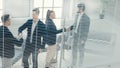 Through the blinds. young business people shaking hands with each other. Royalty Free Stock Photo