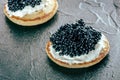 A blini with caviar and cream cheese, a close-up on black