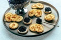 Blinis with black caviar and cream cheese, on a festive dish, mini pancakes