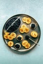 Blinis with black caviar and cream cheese, shot from the top on a festive dish