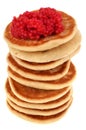 Blinis with red lump eggs in closeup on white background