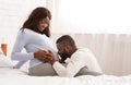 Blissful man kissing his happy pregnant wife belly Royalty Free Stock Photo