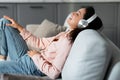 Joyful woman relaxing with music on headphones, eyes closed