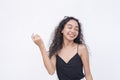 A blissful young asian with a radiant smile closes her eyes while enjoying the moment. Isolated on a white backdrop