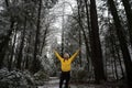 Blissful young woman celebrating life standing in winter forest