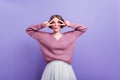 Blissful young woman fooling around while posing in trendy purple sweater. Graceful lady with dark-brown hair making