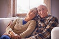 Blissfully indifferent to time. A portrait of a happy senior couple sitting in their living room at home. Royalty Free Stock Photo