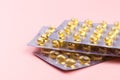 Blister pack of fish oil capsules on pastel pink background Royalty Free Stock Photo