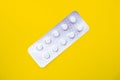 A blister pack of statins, pills tablets for lowering cholesterol on yellow background, prevention and treatment of Royalty Free Stock Photo