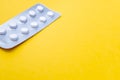 A blister pack of statins, pills tablets for lowering cholesterol on yellow background, prevention and treatment of Royalty Free Stock Photo
