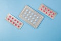 Blister packs of blue and pink pills on blue background