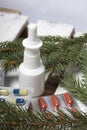 The blisters with pills. Different colors. Nasal spray. Spruce branches. On a wooden box