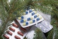 The blisters with pills. Different colors. Spruce and pine branches with cones. On a wooden box Royalty Free Stock Photo